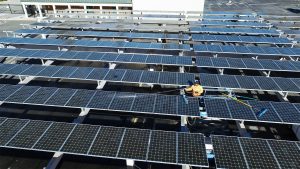 a man sprays down solar panels with deionized water